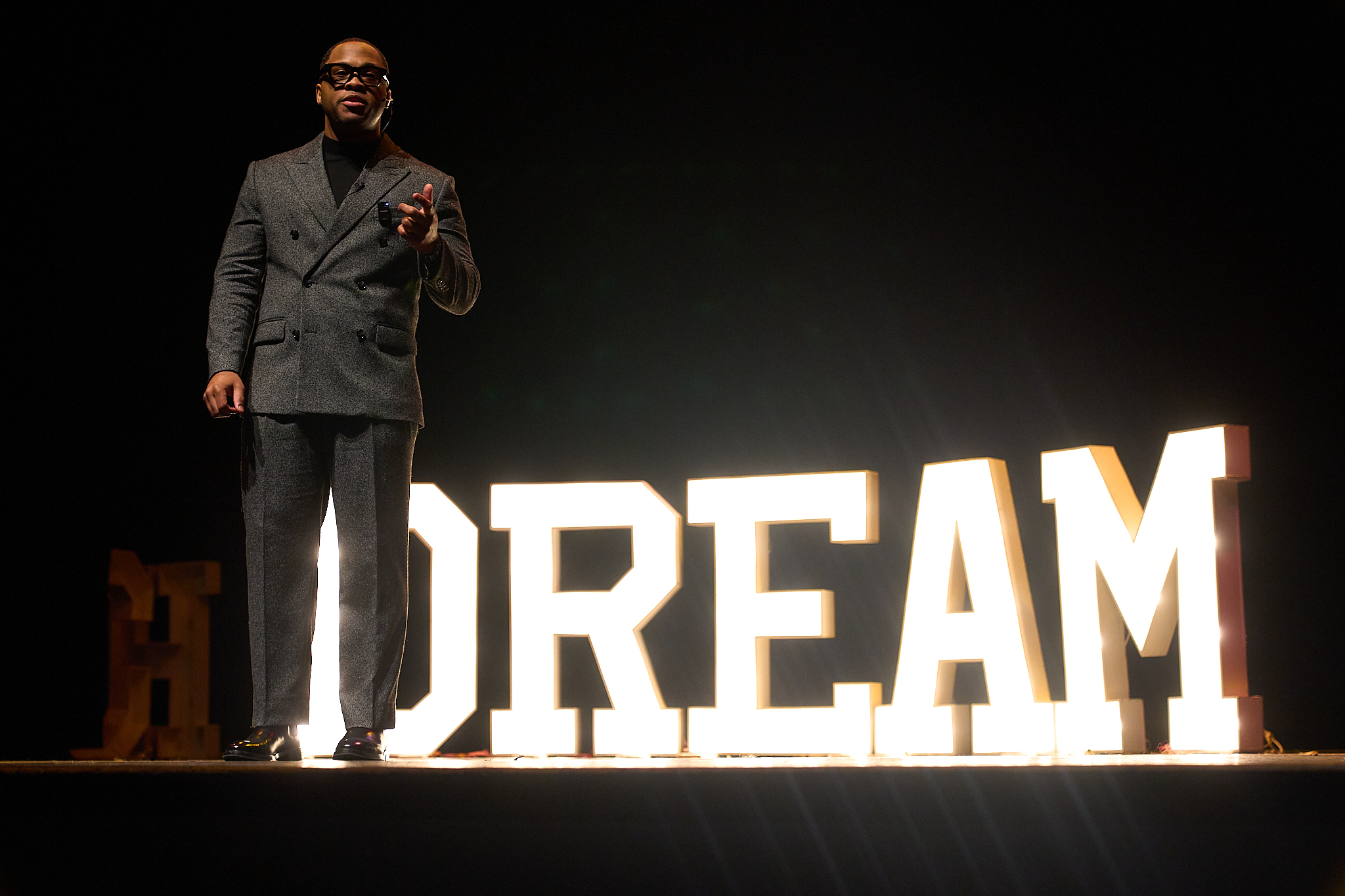 Dion on stage with illuminated DREAM letters